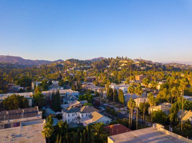 Palmiye ağaçları batımında Los Angeles'ta Hollywood yazısını ufukta ile Beverly Hills sokak.