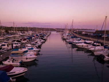 Güzel hava günbatımı manzarası iskelede yerleştirilmiş birçok lüks yatların ile Dock üzerinden.