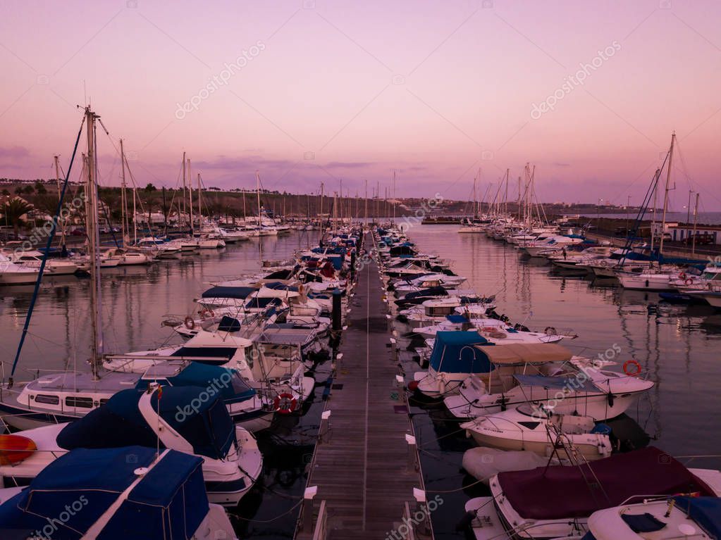 Bella vista sul tramonto aereo sulle banchine con molti yacht di lusso attraccati dal molo
.