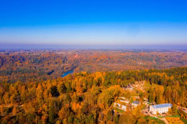 Altın Sonbahar mevsiminde Sigulda kalenin havadan görünümü. Kalenin çevresinde turuncu akçaağaç. 
