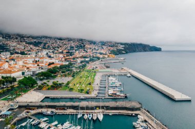Havadan görünümü Funchal eski şehir - Madeira Adası bulutlu hava sırasında başkenti. Atlantik Okyanusu ile turuncu çatıları ile küçük evler.