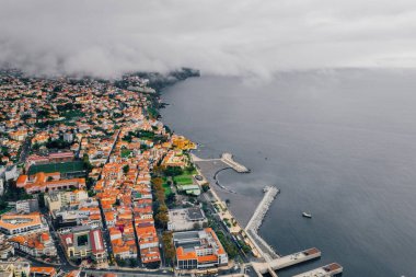 Havadan görünümü Funchal eski şehir - Madeira Adası bulutlu hava sırasında başkenti. Atlantik Okyanusu ile turuncu çatıları ile küçük evler.