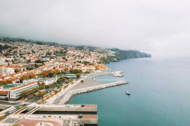 Havadan görünümü Funchal eski şehir - Madeira Adası bulutlu hava sırasında başkenti. Atlantik Okyanusu ile turuncu çatıları ile küçük evler.