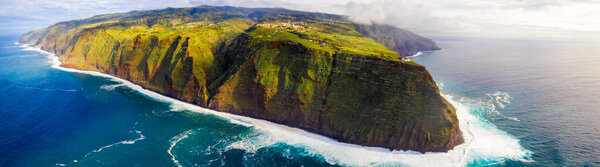 Aerial Madeira island view with Atlantic ocean, white waves, cliffs and green nature