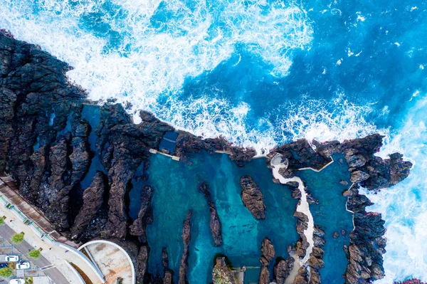 Aerial view of the ocean island cliffs with huge white waves and crystal blue water