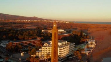Gran Canaria ada Maspalomas dunes yakınındaki büyülü gün batımı sırasında Meloneras bölgesinde hava deniz feneri görünümü.