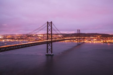 10 Haziran 2018. Lizbon, Portekiz. 25 de Abril köprü Almada Lizbon Tejo Nehri'nin sol yakasında Belediyesi Lizbon şehir bağlanma bir köprüdür. Gün batımı ışıklar.