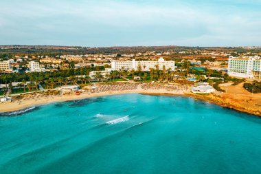 Ayia Napa 'daki Nissi plajı, Kıbrıs' taki ünlü turist plajının temiz hava fotoğrafı. Kıbrıs 'ın en iyi tatil yeri, Nissi plajı, oteller, körfezler, parklar.