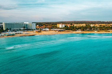 Ayia Napa 'daki Nissi plajı, Kıbrıs' taki ünlü turist plajının temiz hava fotoğrafı. Kıbrıs 'ın en iyi tatil yeri, Nissi plajı, oteller, körfezler, parklar.