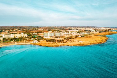 Ayia Napa 'daki Nissi plajı, Kıbrıs' taki ünlü turist plajının temiz hava fotoğrafı. Kıbrıs 'ın en iyi tatil yeri, Nissi plajı, oteller, körfezler, parklar.