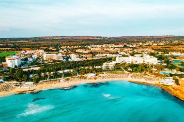 Ayia Napa 'daki Nissi plajı, Kıbrıs' taki ünlü turist plajının temiz hava fotoğrafı. Kıbrıs 'ın en iyi tatil yeri, Nissi plajı, oteller, körfezler, parklar.