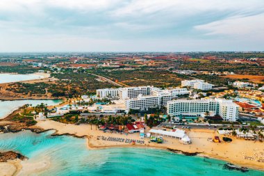 Ayia Napa 'daki Nissi plajı, Kıbrıs' taki ünlü turist plajının temiz hava fotoğrafı. Kıbrıs 'ın en iyi tatil yeri, Nissi plajı, oteller, körfezler, parklar.