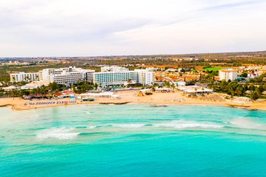 Ayia Napa 'daki Nissi plajı, Kıbrıs' taki ünlü turist plajının temiz hava fotoğrafı. Kıbrıs 'ın en iyi tatil yeri, Nissi plajı, oteller, körfezler, parklar.