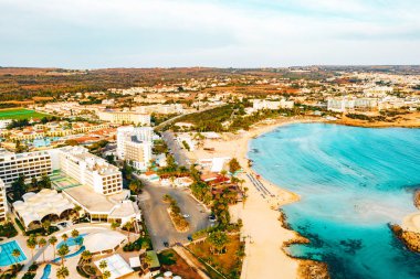 Ayia Napa 'daki Nissi plajı, Kıbrıs' taki ünlü turist plajının temiz hava fotoğrafı. Kıbrıs 'ın en iyi tatil yeri, Nissi plajı, oteller, körfezler, parklar.
