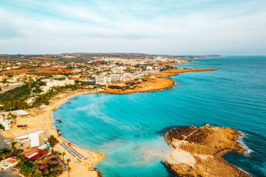 Ayia Napa 'daki Nissi plajı, Kıbrıs' taki ünlü turist plajının temiz hava fotoğrafı. Kıbrıs 'ın en iyi tatil yeri, Nissi plajı, oteller, körfezler, parklar.