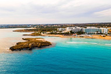 Ayia Napa 'daki Nissi plajı, Kıbrıs' taki ünlü turist plajının temiz hava fotoğrafı. Kıbrıs 'ın en iyi tatil yeri, Nissi plajı, oteller, körfezler, parklar.