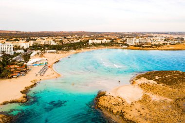 Ayia Napa 'daki Nissi plajı, Kıbrıs' taki ünlü turist plajının temiz hava fotoğrafı. Kıbrıs 'ın en iyi tatil yeri, Nissi plajı, oteller, körfezler, parklar.