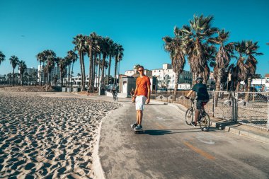 10 Ağustos 2018. Los Angeles, Amerika Birleşik Devletleri. Venice beach vibes. İnsanlar bir tekerlek binme, Bisiklet ve kaykaylar plaj ve avuç içi aşağı. Yaz ruhu. 