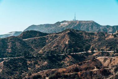 10 Haziran 2018. Hollywood, Amerika Birleşik Devletleri. Hollywood yazısını işareti için önde gelen bir sokak ile mesafeden güzel görünümü.