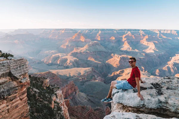 Młody Człowiek Siedzi Skraju Wielkiego Kanionu Usa Oglądając Zachód Słońca — Zdjęcie stockowe