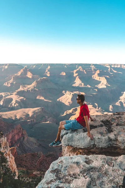 Młody Człowiek Siedzi Skraju Wielkiego Kanionu Usa Oglądając Zachód Słońca — Zdjęcie stockowe