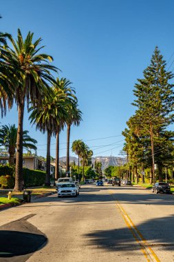10 Haziran 2018. Los Angeles, Amerika Birleşik Devletleri. Beyaz Ford Mustang Gt Los Angeles'ta Hollywood sign tarafından sokakta park.