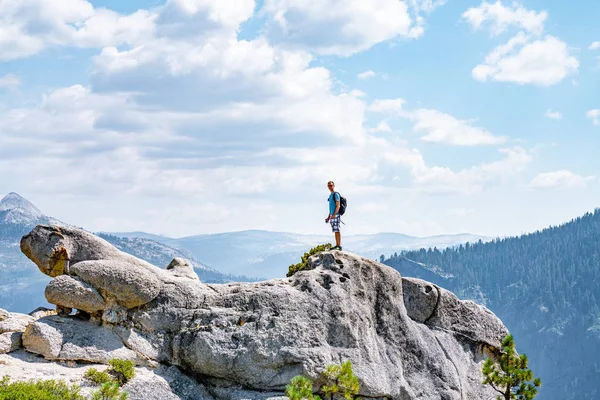 站在悬崖边缘欣赏约塞米蒂国家公园半顶悬崖对面的年轻人 — 图库照片