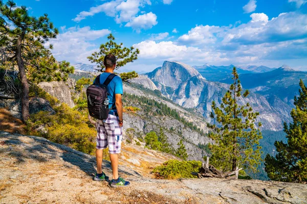 Hiking Yosemite Ulusal Parkı'nda genç adam. Kurtlar Vadisi keşfetmek, şelale ve yarım kubbe yollar.
