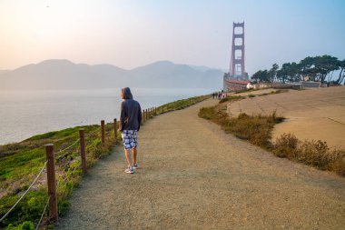 Golden Gate Köprüsü San Francisco yakınlarındaki yürüyen genç adam. California keşfetmek.
