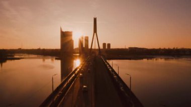 Riga, Letonya'nın havadan turuncu gün batımı zaman atlamalı. Eski şehir ve şehir merkezi yakınındaki Daugava Nehri üzerindeki köprüde güzel şehir hayatı. 