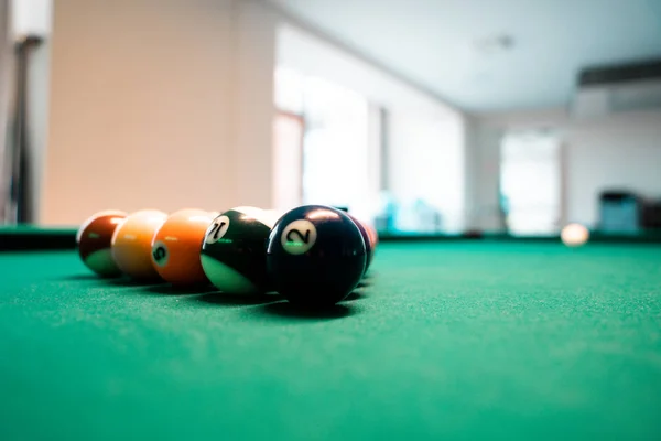 Billiard Balls and a Pool table. A Vintage style photo of a billiard balls on a pool table with a cue stick.