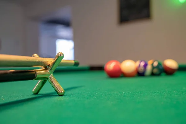 Billiard Balls and a Pool table. A Vintage style photo of a billiard balls on a pool table with a cue stick.
