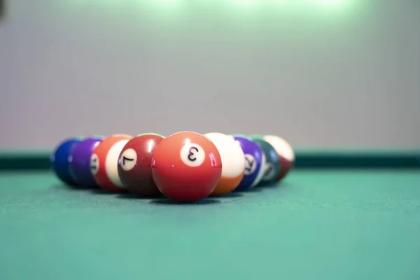 Billiard Balls and a Pool table. A Vintage style photo of a billiard balls on a pool table with a cue stick.