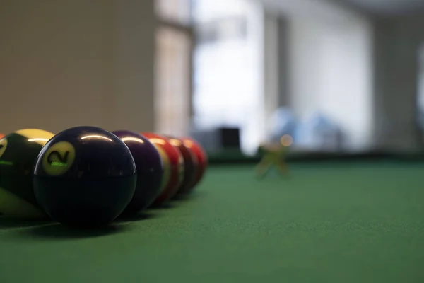 Billiard Balls and a Pool table. A Vintage style photo of a billiard balls on a pool table with a cue stick.