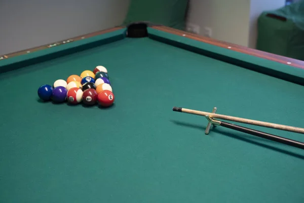 Billiard Balls and a Pool table. A Vintage style photo of a billiard balls on a pool table with a cue stick.