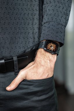 Young businessman wearing a smart watch, holding his hand in a pocket. 