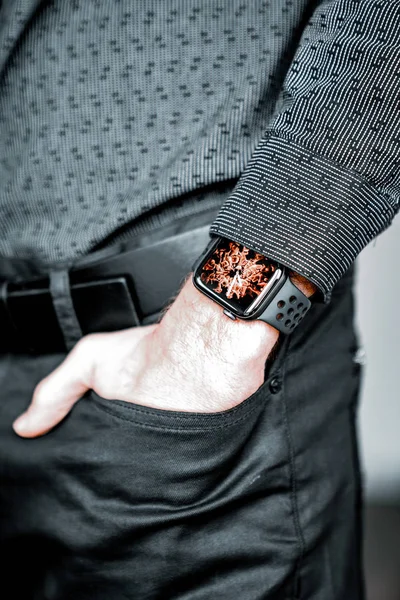 Young businessman wearing a smart watch, holding his hand in a pocket.