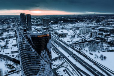 March 10, 2019. Riga, Latvia. Aerial view on the Swedbank building in Riga during winter evening at sunset.   clipart