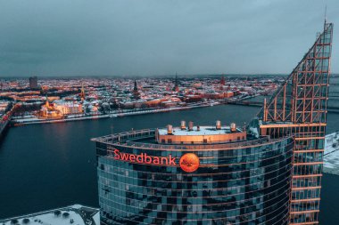 March 10, 2019. Riga, Latvia. Aerial view on the Swedbank building in Riga during winter evening at sunset.   clipart