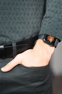 Young businessman wearing a smart watch, holding his hand in a pocket.