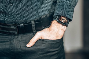 Young businessman wearing a smart watch, holding his hand in a pocket.