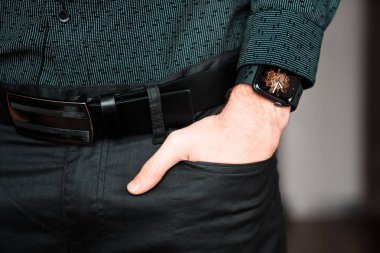 Young businessman wearing a smart watch, holding his hand in a pocket.