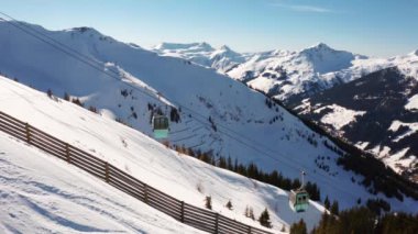 Avusturya Alpleri'ndeki kayak merkezinin havadan görünümü, geniş kayak pistleri, teleferikler ve kayalıklardan inip çıkan asansörler. Güzel Saalbach kayak merkezi.