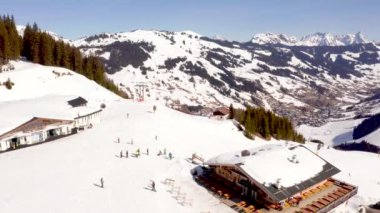 Avusturya Alpleri'ndeki kayak merkezinin havadan görünümü, geniş kayak pistleri, teleferikler ve kayalıklardan inip çıkan asansörler. Güzel Saalbach kayak merkezi.