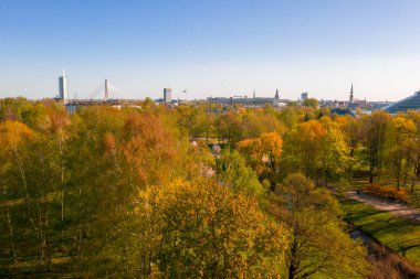 Arka planda Riga eski şehir ile güzel hava parkı görünümü. Güneşli günde Yeşil Zafer parkı.