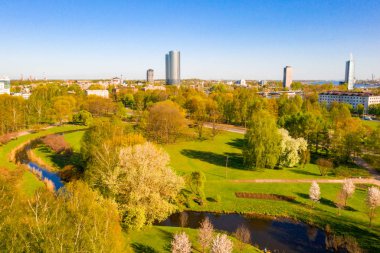Arka planda Riga eski şehir ile güzel hava parkı görünümü. Güneşli günde Yeşil Zafer parkı.