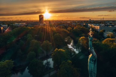 Central Park ve özgürlük heykeli yakınındaki Riga üzerinde gün batımı görünümü.