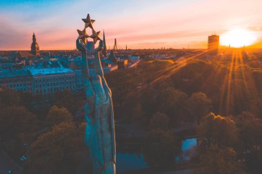 Central Park ve özgürlük heykeli yakınındaki Riga üzerinde gün batımı görünümü.  