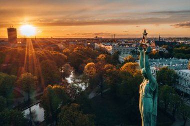 Central Park ve özgürlük heykeli yakınındaki Riga üzerinde gün batımı görünümü.  