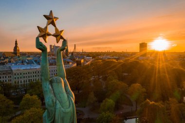 Central Park ve özgürlük heykeli yakınındaki Riga üzerinde gün batımı görünümü.  